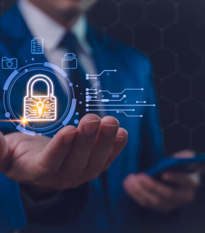 A businessman in a blue suit interacts with a futuristic holographic security interface, featuring a glowing padlock symbol, signifying advanced digital protection. Secure business networks A businessman in a blue suit interacts with a futuristic holographic security interface, featuring a glowing padlock symbol, signifying advanced digital protection. Secure business networks