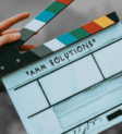 Infraestrutura de TI para produtoras audiovisuais | AMM Solutions Claquete de cinema representando a infraestrutura tecnológica para produtoras audiovisuais, tema discutido durante o AMM Solutions Experience.