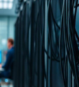 Profissionais trabalhando em um ambiente de infraestrutura de TI com racks de servidores corporativos em um datacenter moderno.